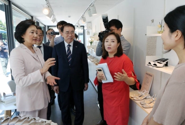 박영선 중소벤처기업부 장관(앞줄 왼쪽 첫 번째)과 조용병 신한금융그룹 회장(사진 왼쪽)이 예비창업 사업모델에 대해 설명을 듣고 있다. (사진=신한금융그룹)