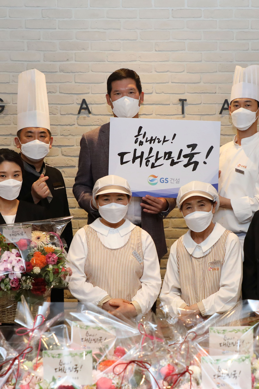 지난 18일 서울 종로구의 본사 사원식당에서 화훼농가 지원을 위한 허윤홍 GS건설 신사업부문 대표(윗줄 왼쪽 셋째)가 사원식당 외주업체 직원과 기념사진을 찍고 있다. (사진=GS건설)