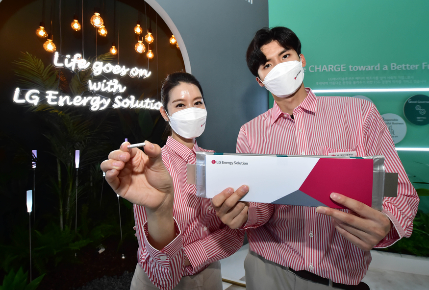 LG에너지솔루션 관계자들이 '인터배터리 2021' 행사에서 초소형 원통형 배터리(왼쪽)와 파우치형 배터리인 롱셀(오른쪽)을 들고 포즈를 취하고 있는 모습. (사진=LG에너지솔루션)