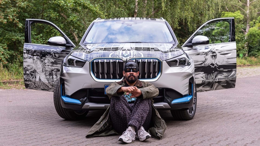 마크 브랜든버그가 자신이 디자인한 BMW iX1 앞에 앉아있다. (사진=BMW)