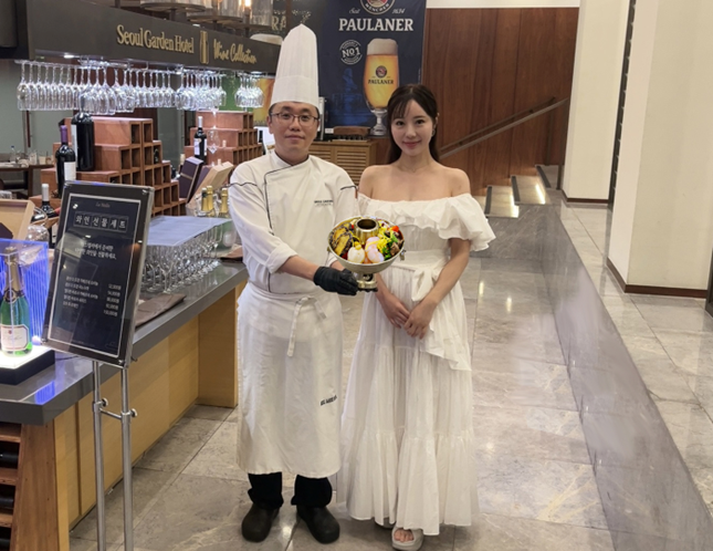 서울가든호텔 뷔페에서 신선로 메뉴를 들고 있는 박종화 총주방장과 일본인 마사미(MASAMI HIGASHI) 인플루언서.(사진=서울가든호텔)
