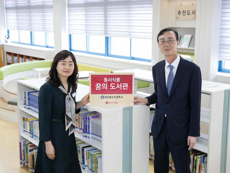 대전 서구 봉산초등학교에서 열린 '꿈의 도서관' 개관식에서 김미애 봉산초등학교 교장(왼쪽)과 최상인 동서식품 상무가 기념촬영을 하고 있다 (사진=동서식품)