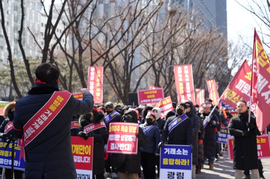 지난 21일 여의도 한국거래소 앞에서 쌍방울·광림·이그룹 소액주주 약 1천여명이 상장폐지 철회를 규탄하며 연대집회를 열고 삭발식을 진행하고 있다. 사진=쌍방울