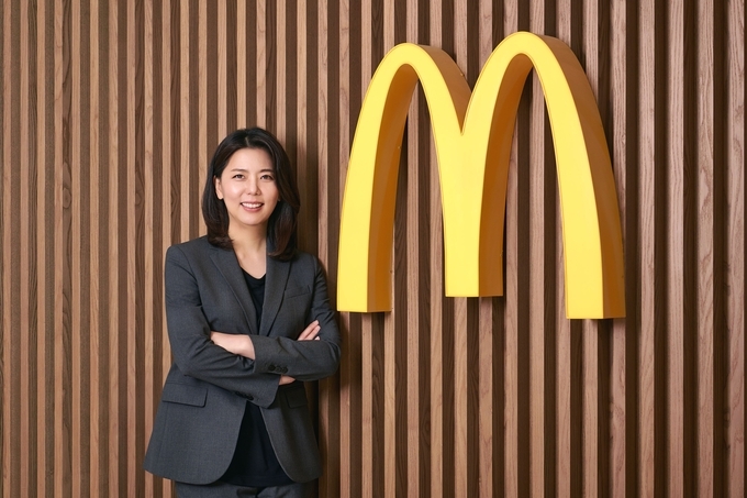 김기원 한국맥도날드 대표가 맥도날드 로고 앞에서 포즈를 취하고 있다. (사진=한국맥도날드