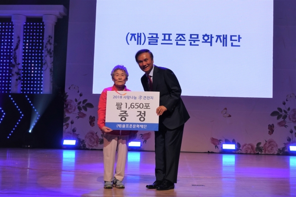 골프존문화재단 김영찬 이사장이 11일 대전 충남대학교 정심화국제문화회관에서 개최된 ‘2018 사랑나눔효큰잔치’에서 어르신께 쌀을 전달하고 있다. 골프존문화재단 김영찬 이사장이 11일 대전 충남대학교 정심화국제문화회관에서 개최된 ‘2018 사랑나눔효큰잔치’에서 어르신께 쌀을 전달하고 있다.