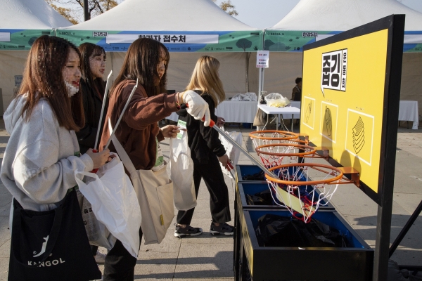 한강 줍깅 참가자들이 이색 쓰레기통에 주워온 쓰레기를 직접 분리배출 하고 있다