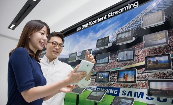 삼성전자 모델들이 5G 통신 속도를 활용해 태블릿으로 UHD 동영상 스트리밍을 시연하고 있다. (사진=삼성전자)